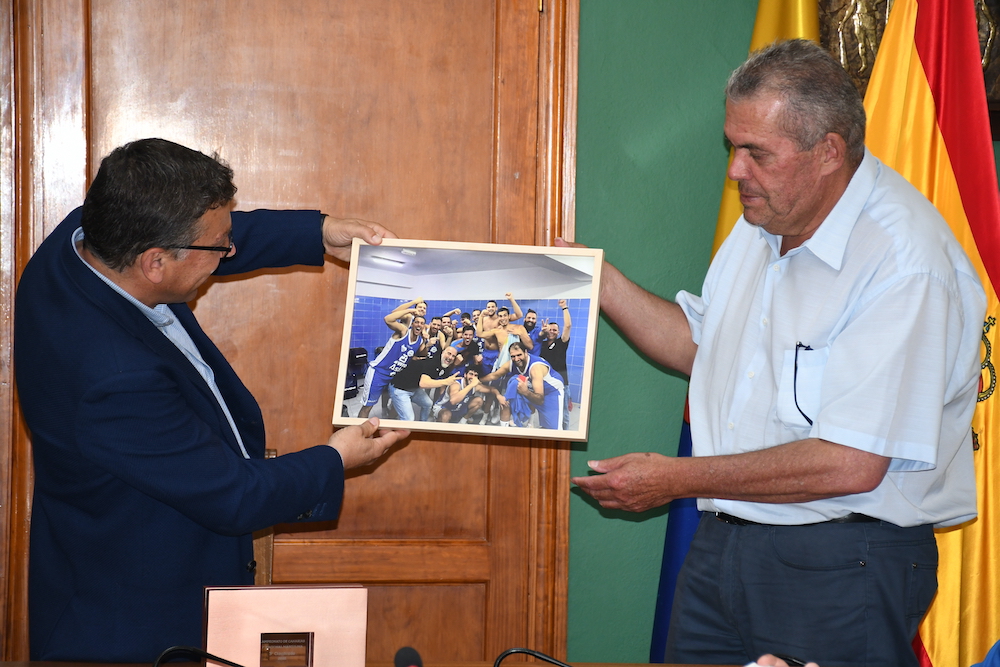 Alcalde y Concejal muestran una foto del momento de celebración al final del partido del ascenso