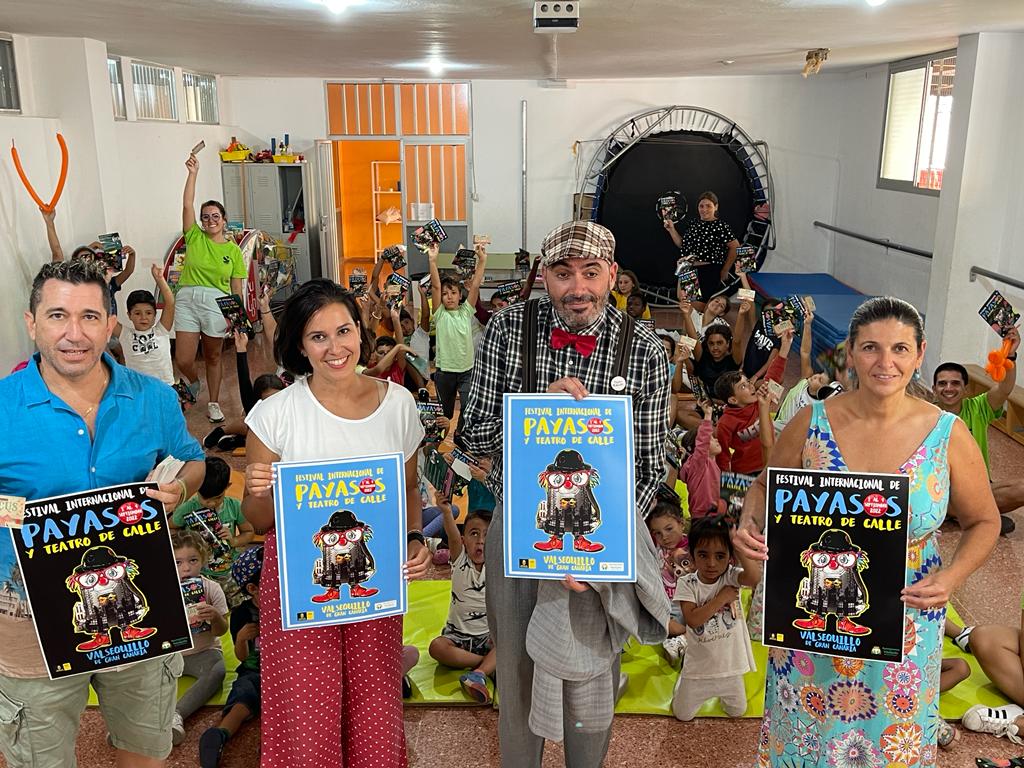 Concejalas y artistas posan con cartel junto a los niños asistentes