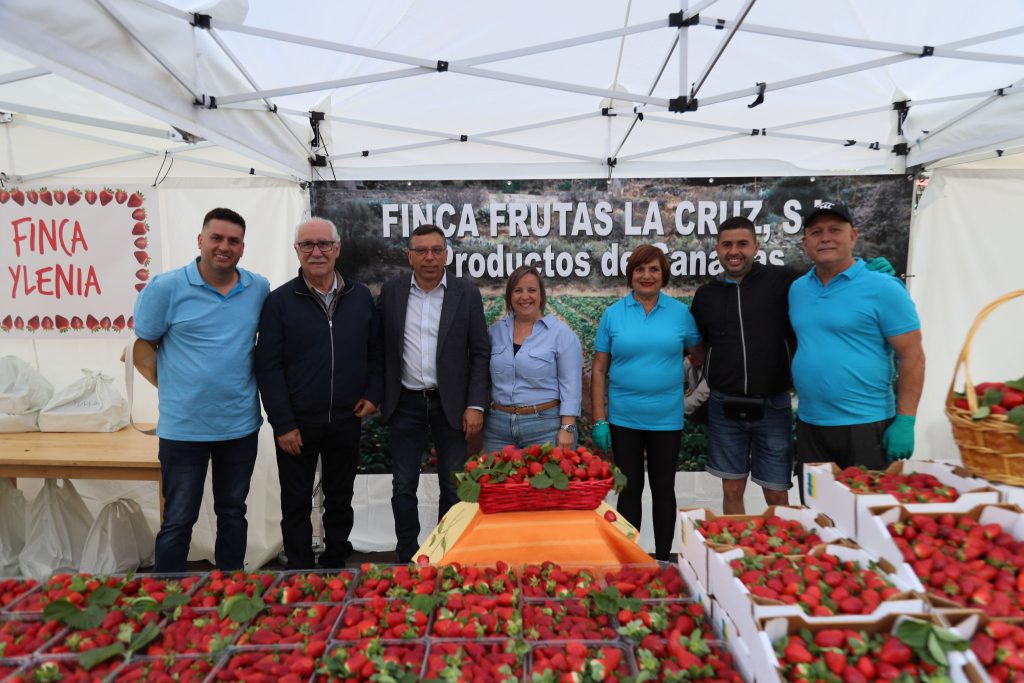 Representantes políticos con miembros de stand de productores de fresas